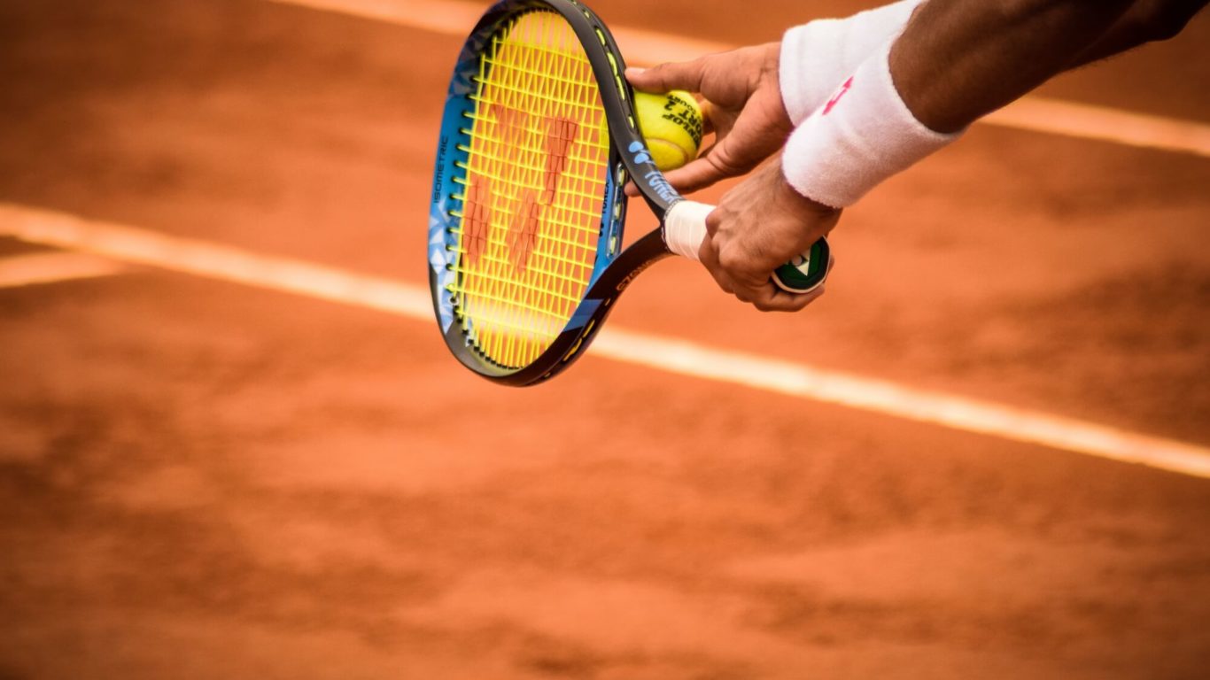 close-up-photo-of-person-holding-tennis-racket-and-ball-1432039